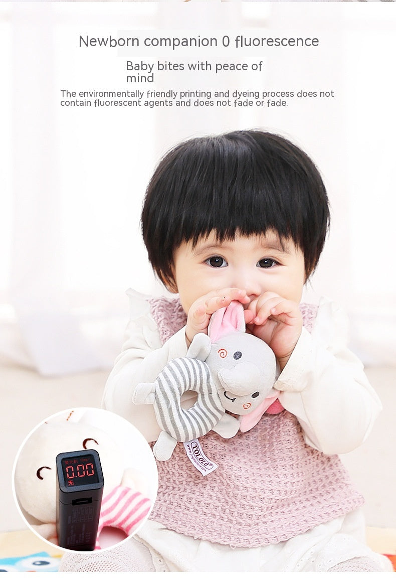 A baby wearing a pink vest, nibbling on an elephant plush toy. The image highlights the product's safety, with text emphasizing non-toxic materials and zero fluorescence.