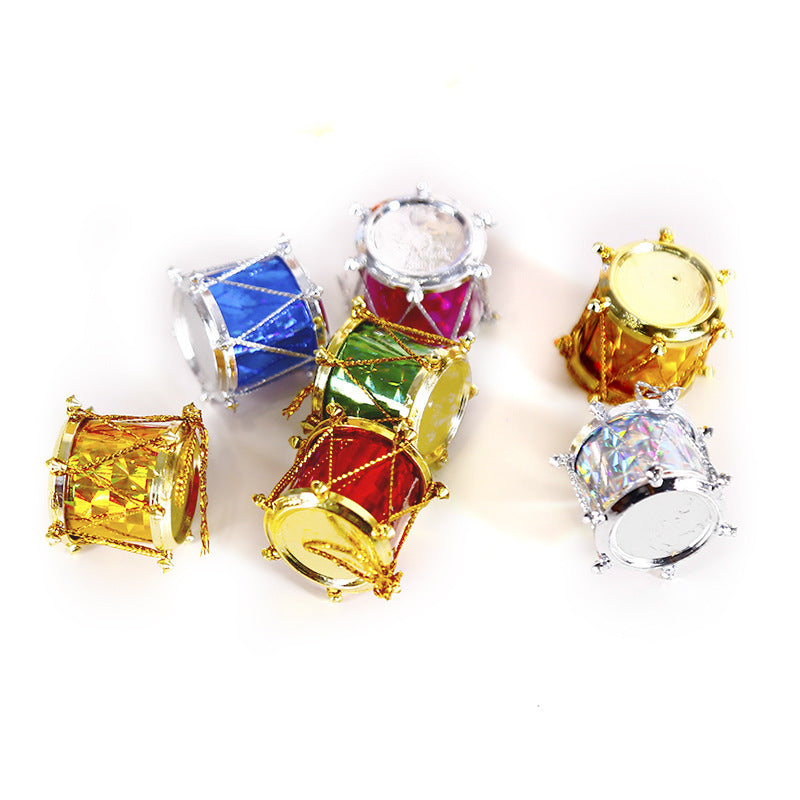 Seven miniature decorative drums in vibrant colors—gold, blue, silver, red, and green—are arranged on a white surface, each adorned with metallic details.