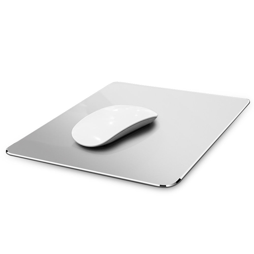 A sleek white computer mouse on a reflective, clear glass mouse pad with rounded edges, set against a plain white background, creating a minimalist tech aesthetic.
