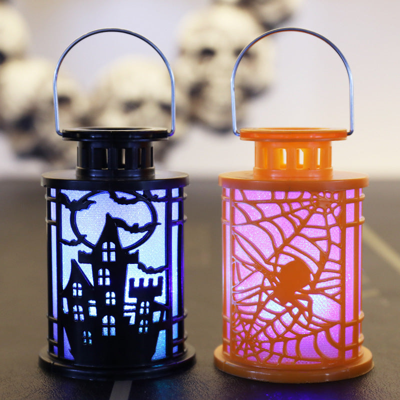 Two Halloween lanterns are shown. The left lantern is black with a spooky house and bat design, glowing blue. The right lantern is orange with a spiderweb and spider motif, illuminated in pink. In the blurred background, there are white skulls.