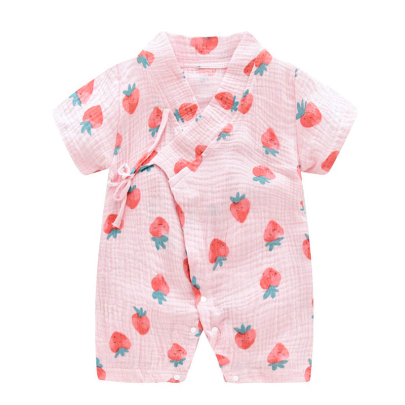 Pink baby romper with short sleeves, featuring a strawberry pattern. Designed with a wrapped front and secured by a side tie, it offers a soft, breathable texture.