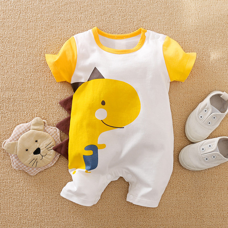 Infant romper with a cute yellow dinosaur print and brown spikes, laid on a textured surface, next to a plush lion toy and a pair of white baby sneakers.