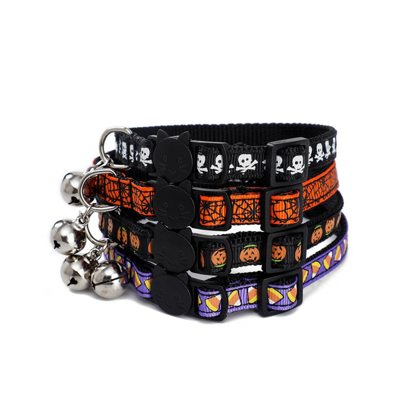 Four Halloween-themed cat collars with patterns of skulls, pumpkins, and candy corn, each featuring a small bell and black cat-shaped clasp.