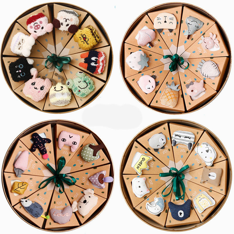 Four round gift boxes each containing colorful, playful cartoon character socks arranged in triangular sections, tied with green ribbons. Each sock features a unique design.