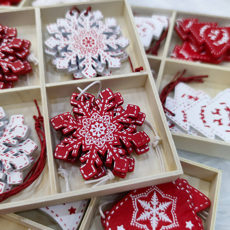 Wooden box with red and white snowflake and Christmas tree ornaments in intricate patterns, neatly arranged in separate compartments.