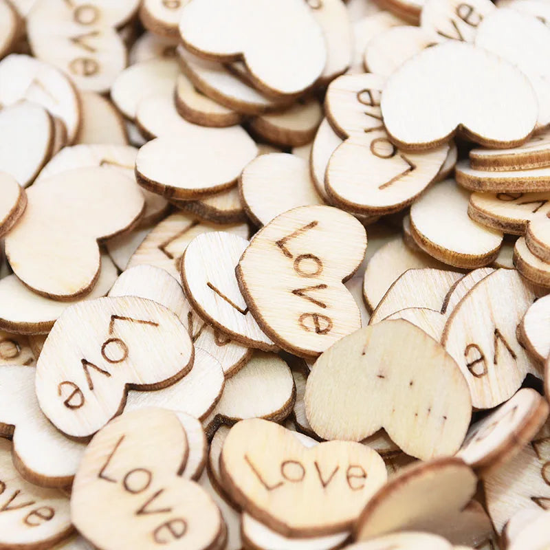 A pile of small wooden heart shapes with the word "Love" engraved on them. The pieces are scattered and layered, showcasing their light brown natural finish.