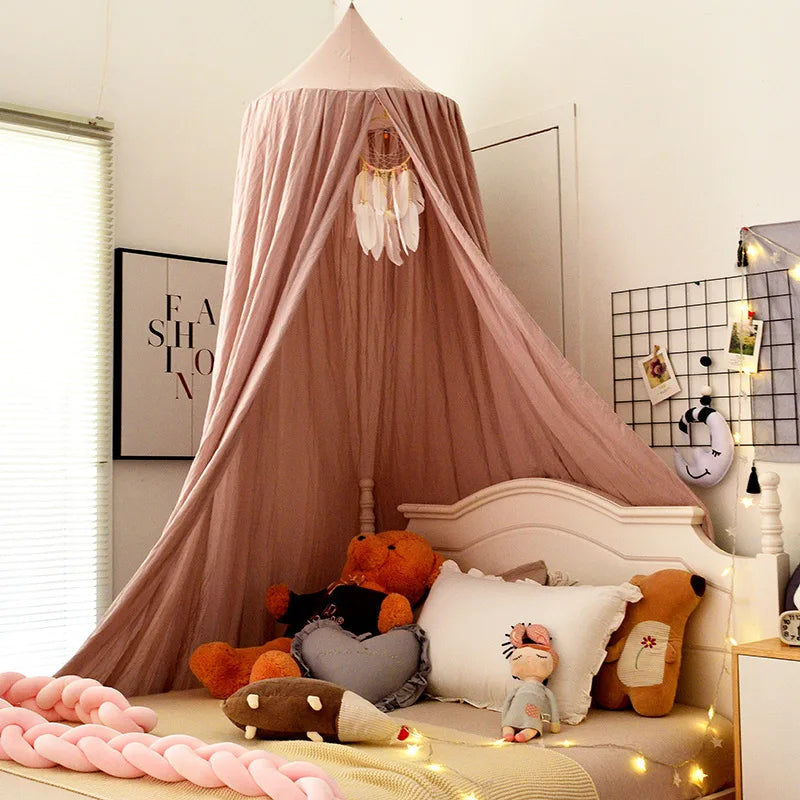 Cozy children's bedroom with a pink canopy over the bed, decorated with plush toys and a dreamcatcher. Soft lighting with string lights creates a warm atmosphere.