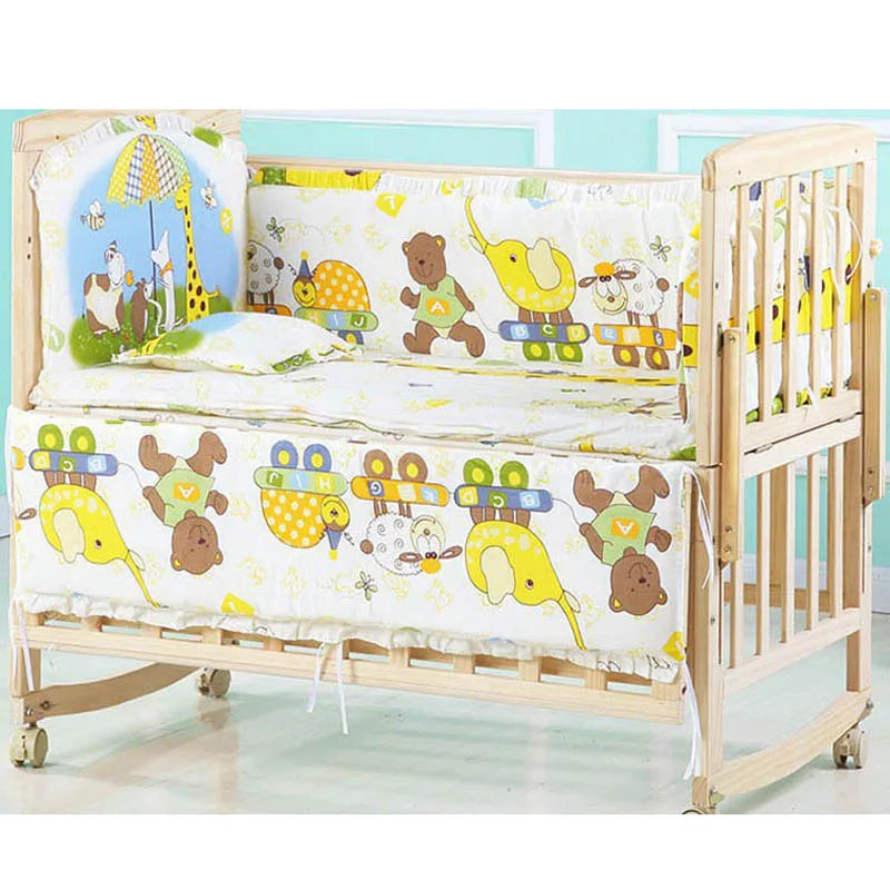 Wooden baby crib with colorful animal-themed bedding, featuring bears, elephants, and turtles. The crib has wheels for easy mobility and a soft mattress inside.