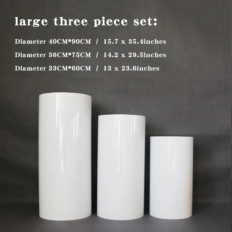 Three white cylindrical pedestals of varying heights displayed against a gray background, labeled as a large three-piece set with corresponding diameters and heights in inches and centimeters.