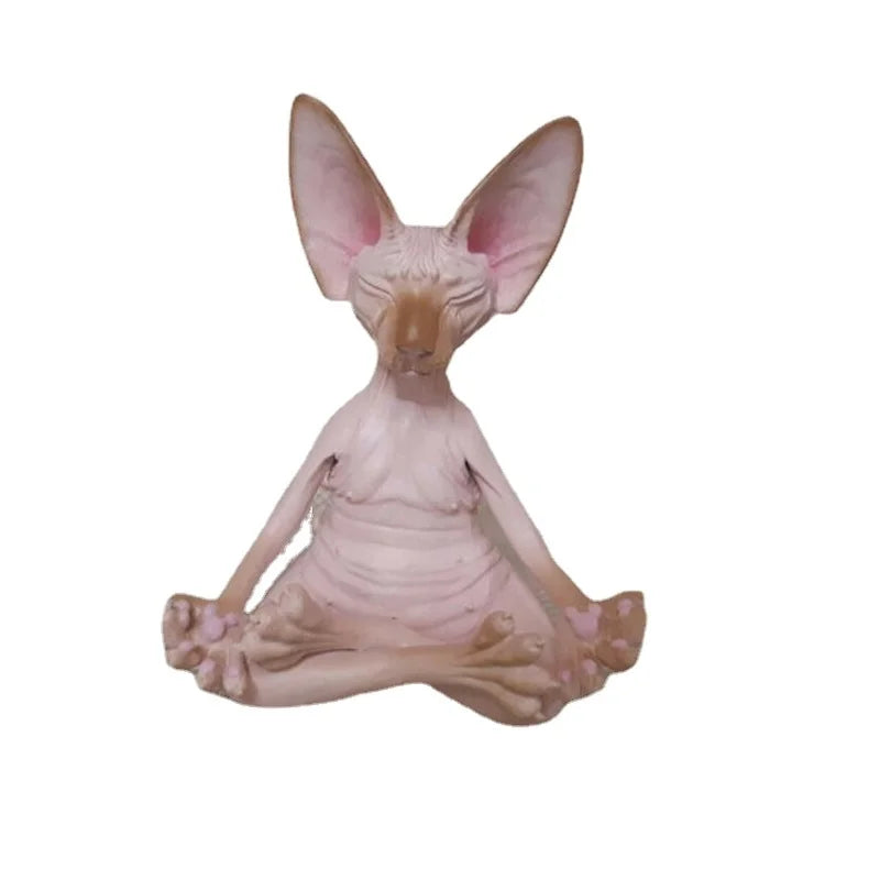 Sculpture of a hairless cat sitting cross-legged, eyes closed, resembling a meditative pose. The cat's large ears and relaxed expression add to the serene appearance.