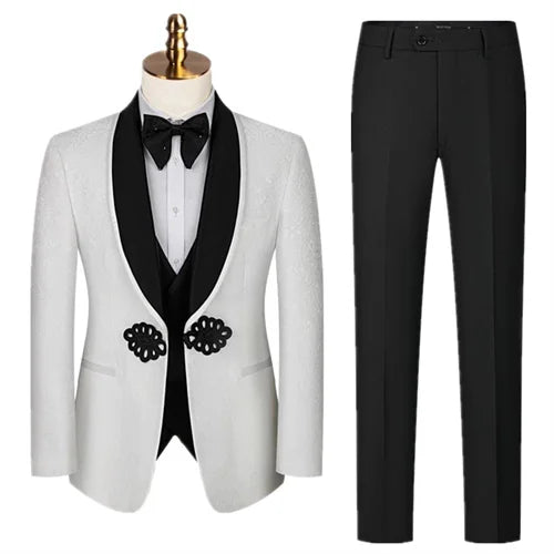 Men's formal outfit featuring a white blazer with black lapels, decorative buttons, and a matching bow tie, paired with black trousers. Suitable for elegant events.