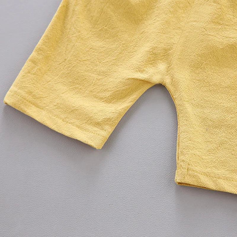 Close-up of a yellow fabric with a textured surface, showing part of a garment's leg opening against a light gray background. The material appears soft and lightweight.