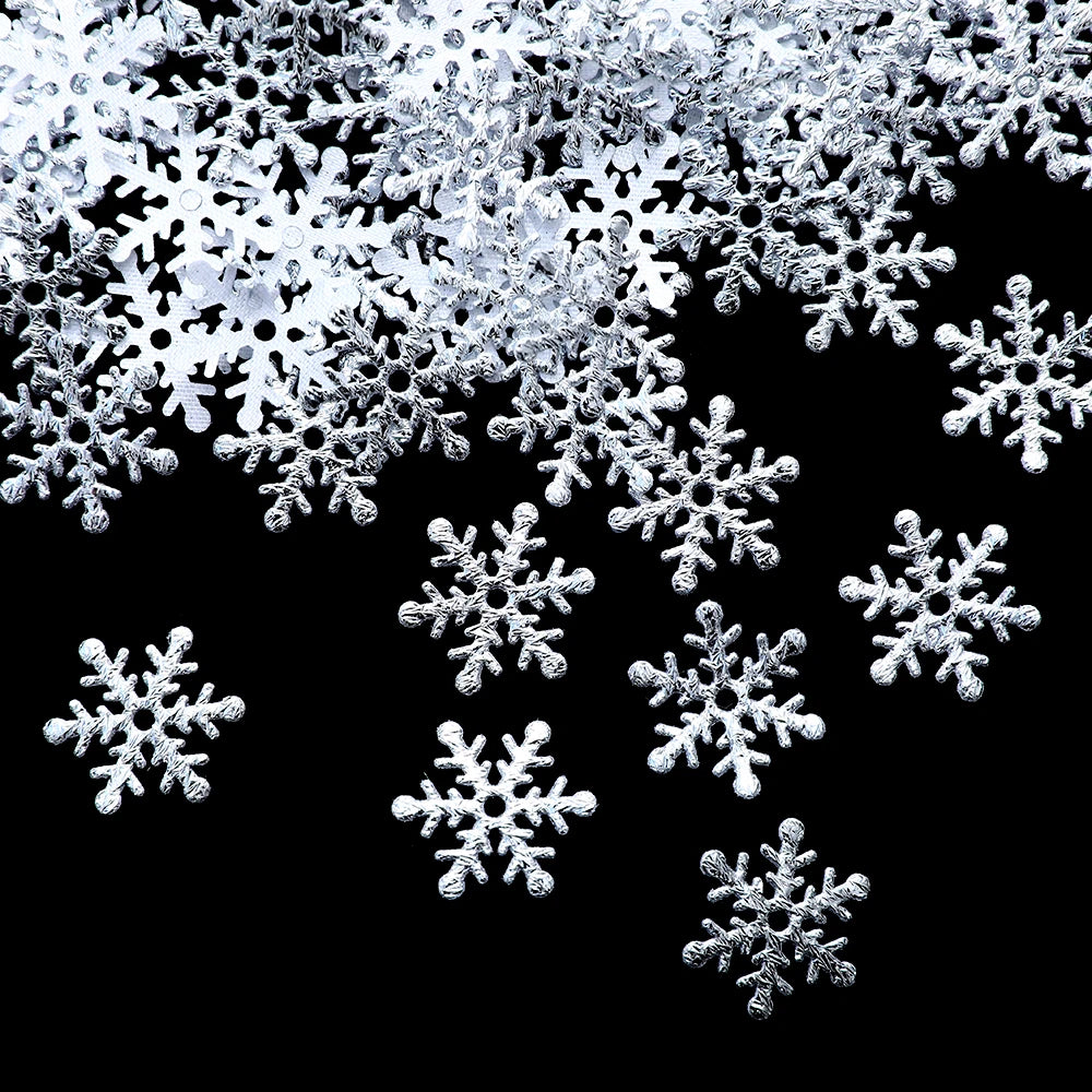 Silver snowflake ornaments scattered on a black background, creating a contrast that highlights their intricate designs and shiny surfaces.