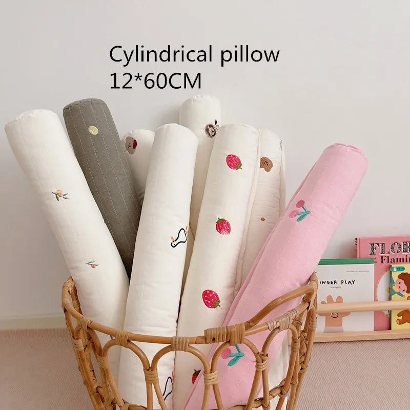 Wicker basket with colorful cylindrical pillows, each with cute patterns like strawberries and animals. The text above reads "Cylindrical pillow 12*60CM."
