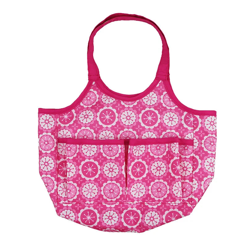 Pink and white tote bag with floral patterns, featuring multiple pockets and pink handles, set against a white background.