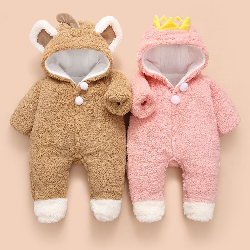 Two plush baby onesies: one brown with bear ears, and one pink with a crown. Both have white cuffs and buttons, on a neutral background.