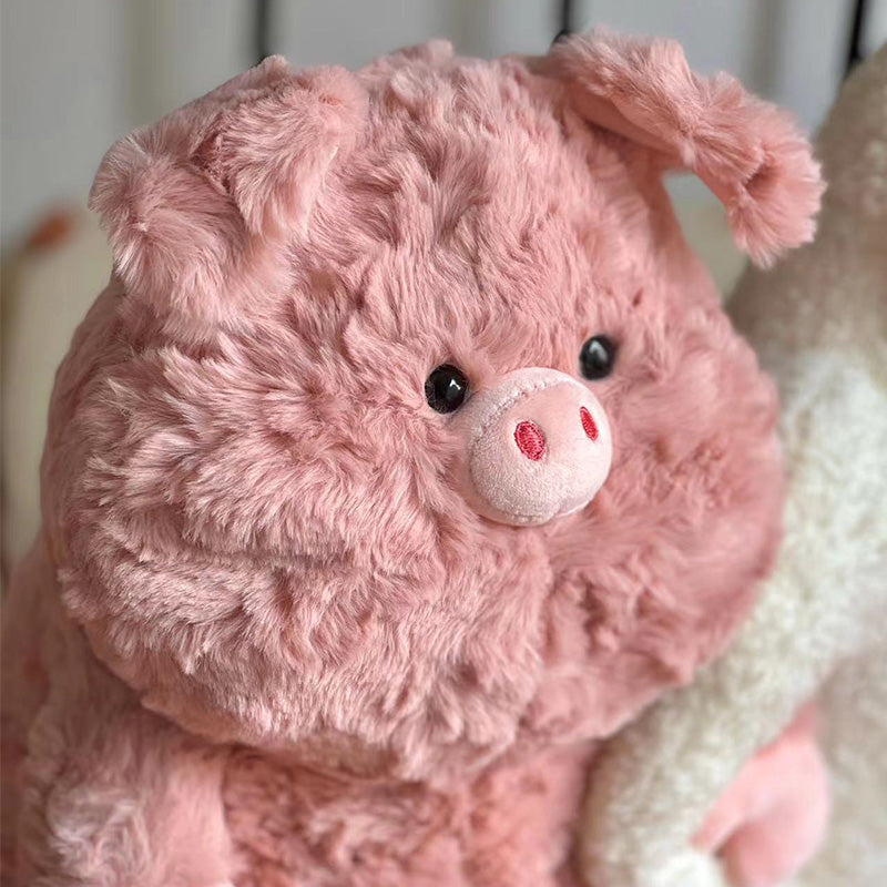 Fluffy pink pig plush toy with round black eyes and a small snout, sporting textured ears. Its soft fur and cute expression make it cuddly and endearing.