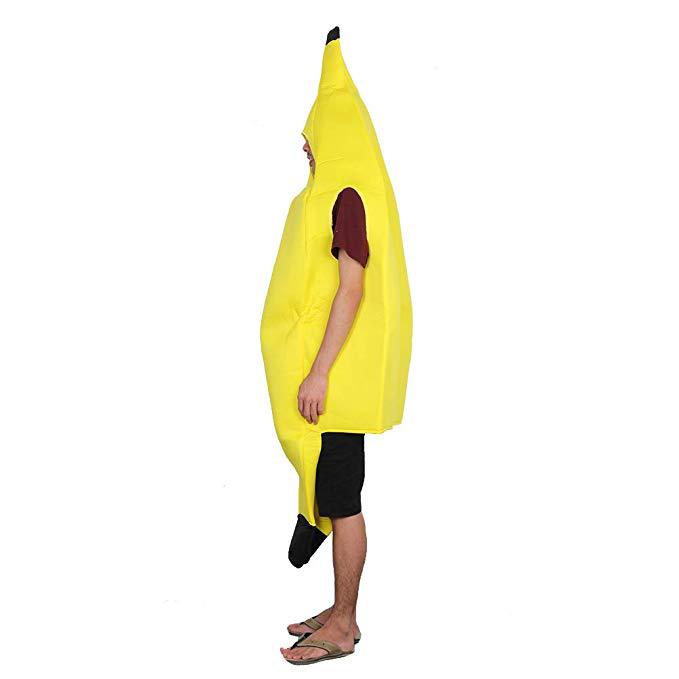 Person wearing a yellow banana costume with brown trim, standing in profile. They wear a red shirt, black shorts, and flip-flops, posing against a white background.