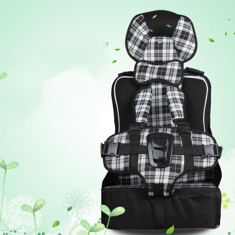 Black and white plaid child car seat with secure harness on a light green, leafy background.