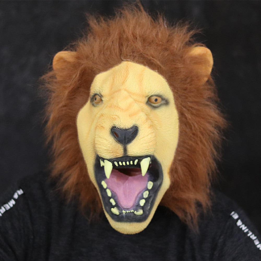 Person wearing a realistic lion mask with an open mouth, exposing sharp teeth. The mask has a mane of brown fur. The background is dark, enhancing the mask’s features.