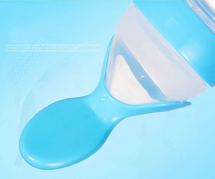 A blue baby food dispensing spoon with a squeezable bottle attachment designed for easy feeding. The spoon is integrated with a container for convenient one-handed use.