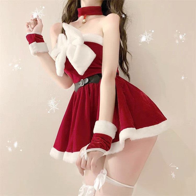 Woman in a red velvet Christmas-themed dress with white fur trim, large white bow, and matching choker. She wears red cuffs and thigh-high stockings, surrounded by snowflakes.