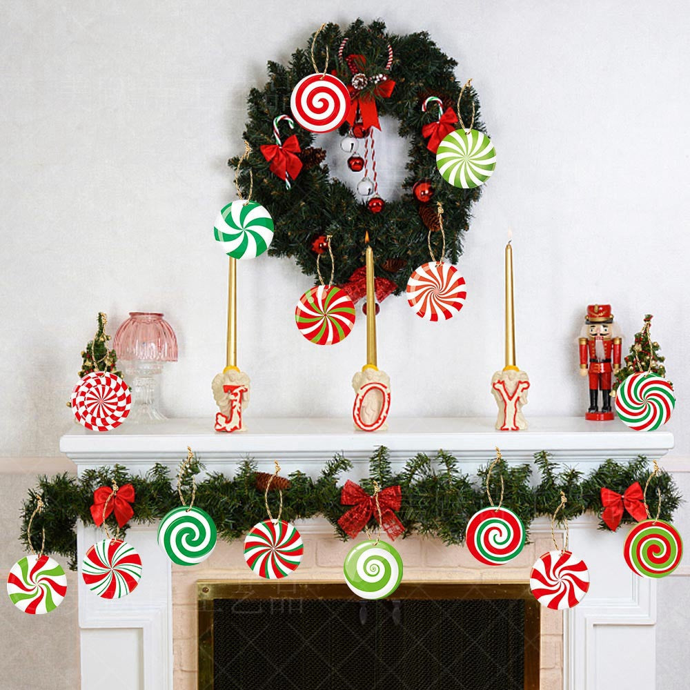 Festive Christmas mantel with green wreath, candy ornaments, red bows, nutcracker, and golden "JOY" candles. Garland with candy swirls adorns the fireplace.