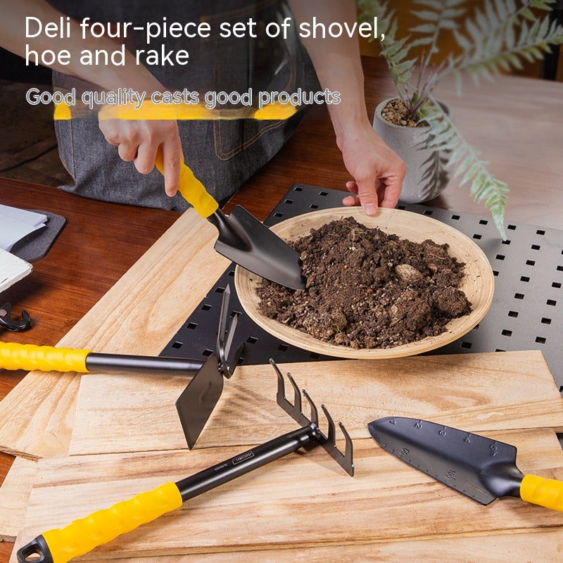 A person uses a small shovel from a four-piece garden tool set with yellow handles, including a hoe and rake. They're preparing soil in a wooden bowl on a table.