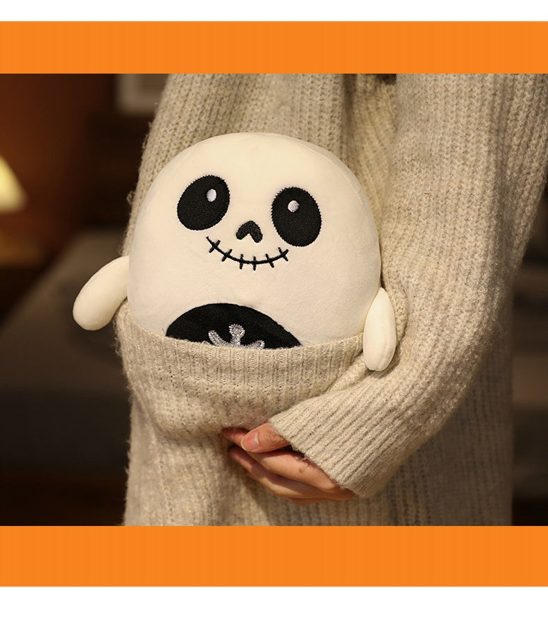 A person in a beige sweater holds a round, cute plush skeleton with a smiling face and stitched details, nestled snugly in their arms.