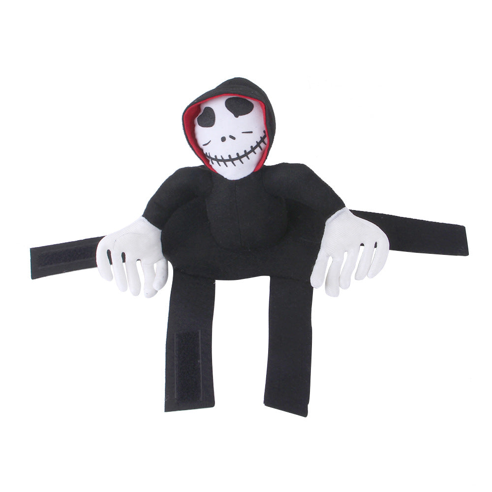 Plush doll resembling a skeleton with a black hooded cloak, white face, and stitched smile. Features Velcro on limbs for attachment. Red hood lining adds contrast.