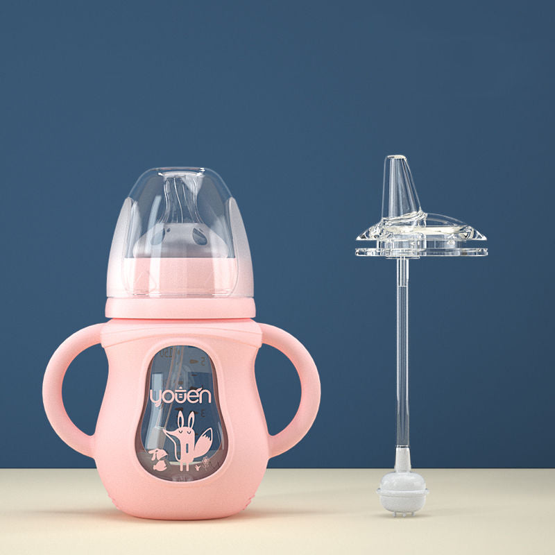 A pink baby sippy cup with handles and a cartoon design, next to a transparent straw attachment, set against a blue background.