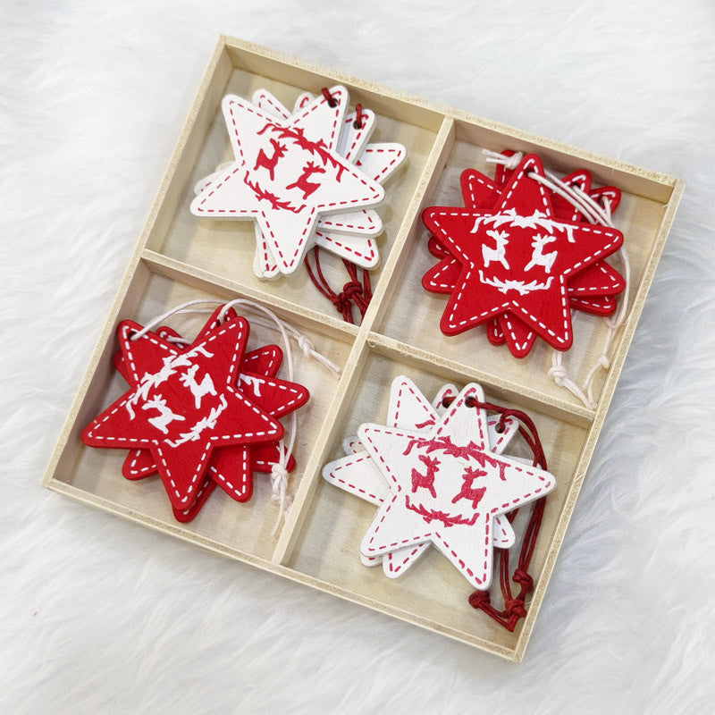 Wooden box with red and white felt star ornaments, featuring reindeer and stitching patterns, arranged in four compartments on a fluffy white surface.