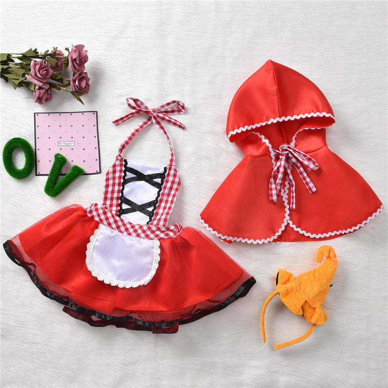 Red Riding Hood costume set includes a red cape, gingham dress with lace apron, and matching plush animal headband; accompanied by pink roses and a decorative card.