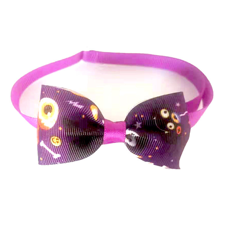 Purple headband with a bow tie featuring a dark, spooky print with eyes and bones. The bow is accented with a bright, solid purple center.
