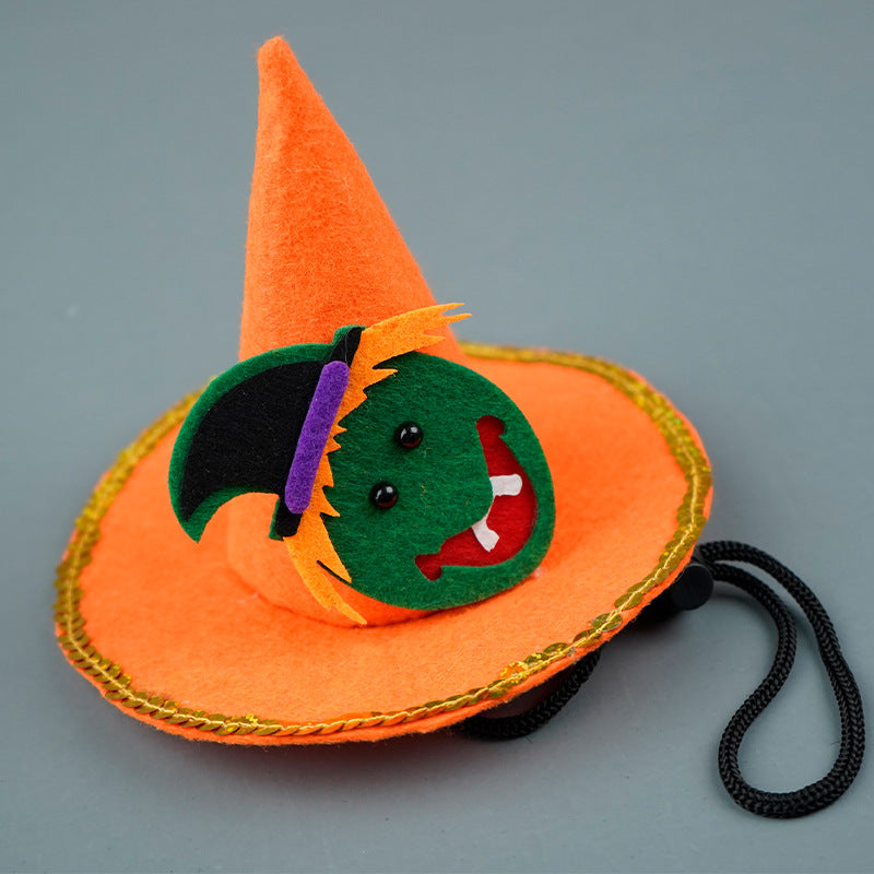 Orange felt witch hat with gold trim and a smiling green face decoration. Features small black eyes, fangs, and an attached black string for securing.