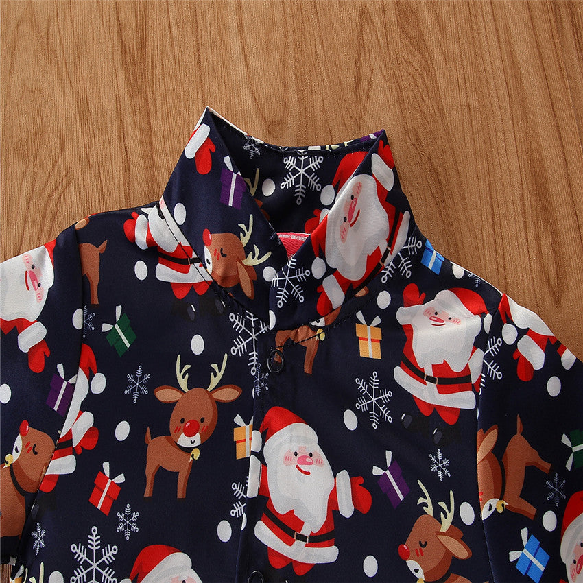 Close-up of a Christmas-themed shirt featuring Santa, reindeer, snowflakes, and colorful gifts on a dark background, displayed on a wooden surface.