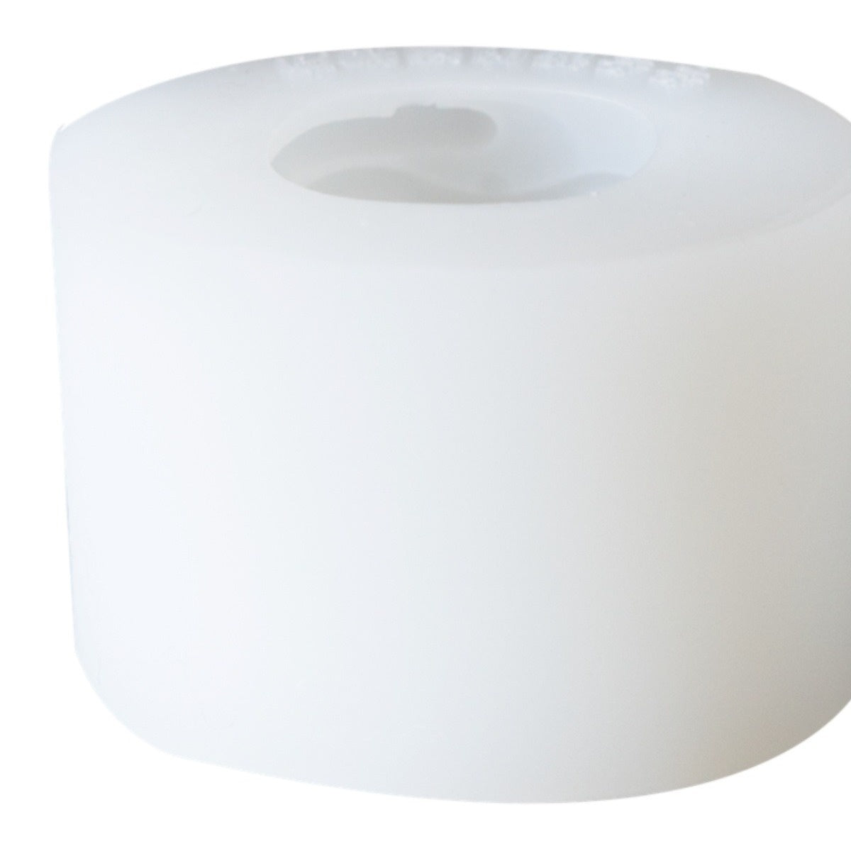 A close-up of a large, white, cylindrical block with a smooth surface and a hollow center, resembling a spool or roll, isolated on a white background.