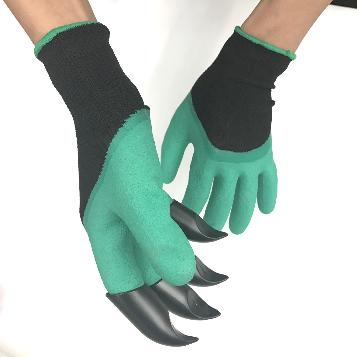 Green and black gardening gloves with attached plastic claws on the fingertips, designed for digging into soil. The hands are positioned against a white background.