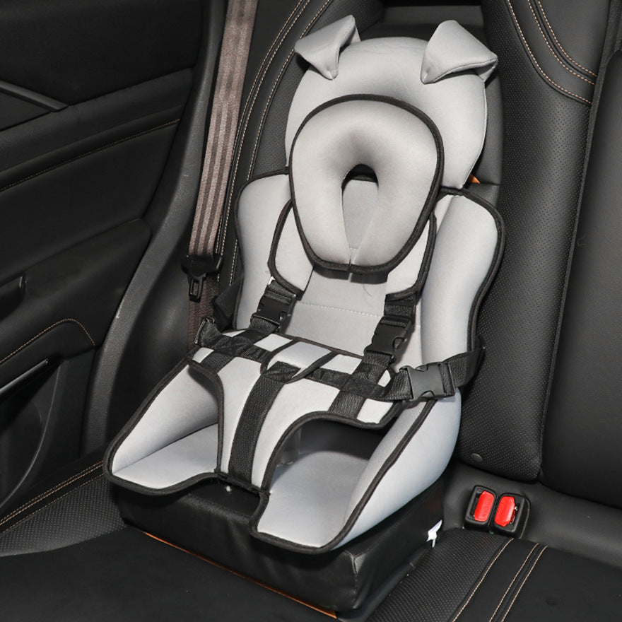 A gray car seat with black straps and a cute animal design sits securely on a dark car interior, ready for a small child.