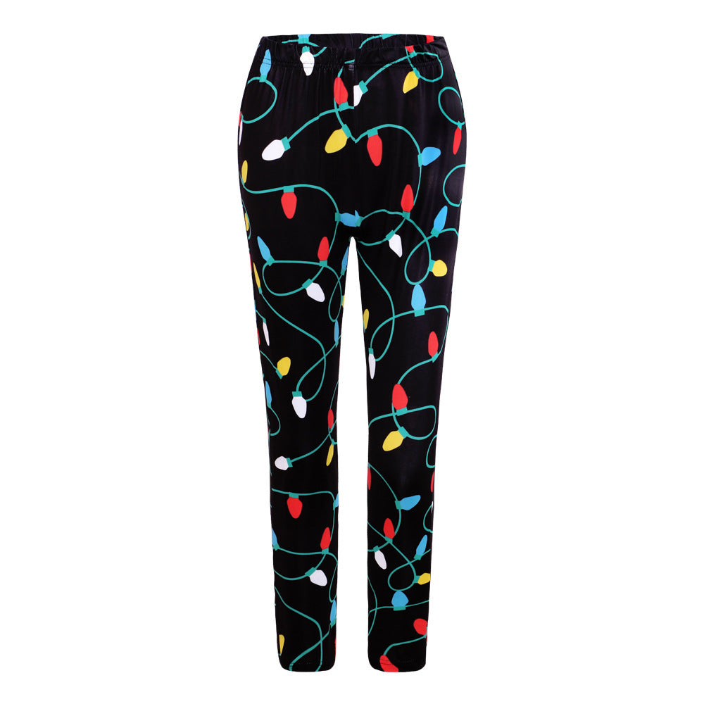 Black pants with a colorful string light design, featuring red, yellow, blue, and white bulbs. The pattern resembles holiday decorations and covers the entire garment.