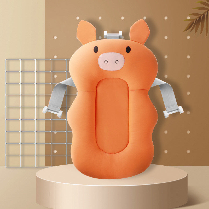 Orange pig-shaped baby bath seat with adjustable gray straps on a beige background with decorative elements.