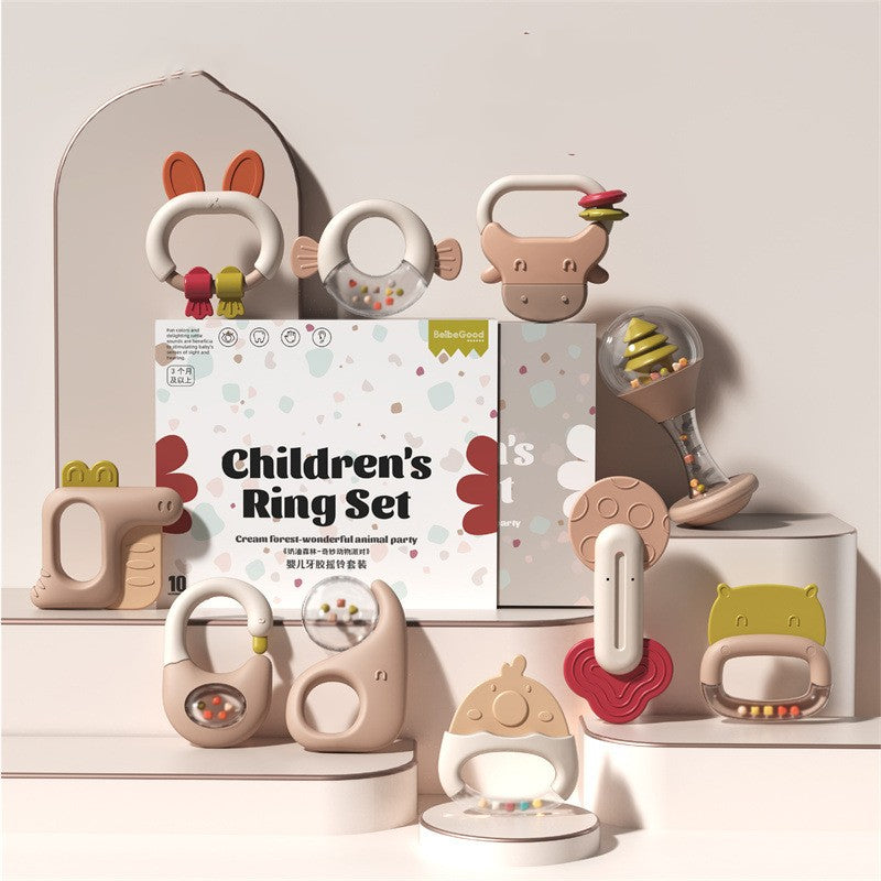 Children's toy ring set with various shapes, including a fish, bear, and dinosaur, in soft pastel colors. Packaged box labeled "Children's Ring Set" in the center.