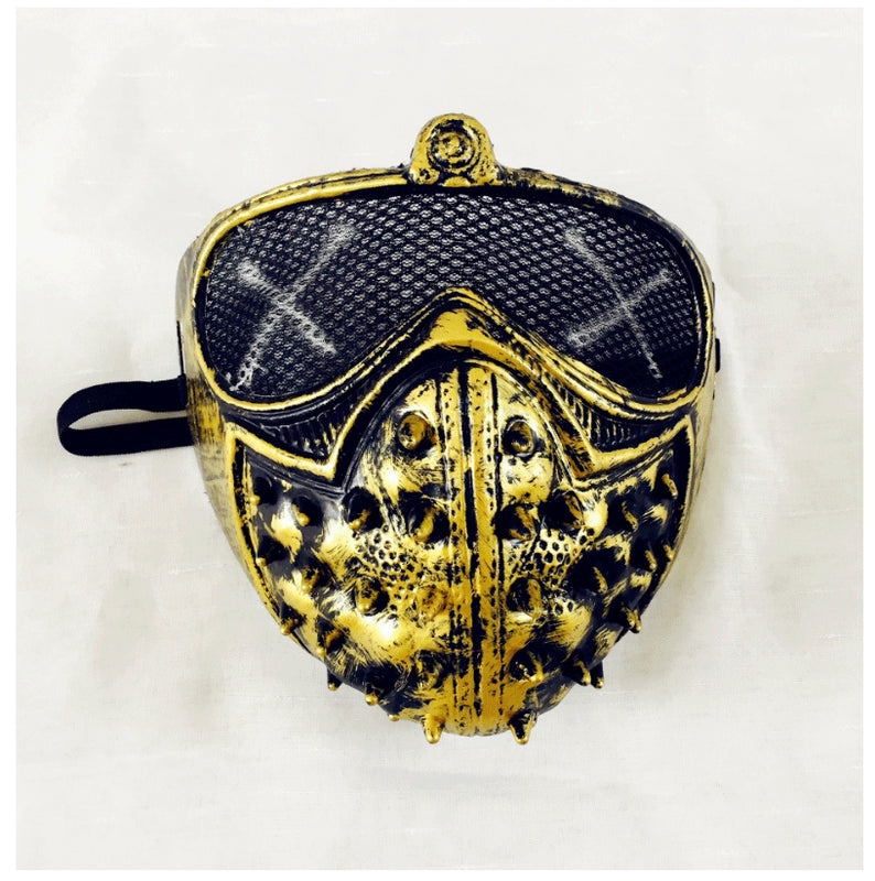 A gold and black mask with a textured, spiked design on the front and mesh eye covering. It features an adjustable strap for wearing and an embossed, ornamental appearance.