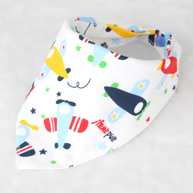 A white baby bib with colorful airplane and star patterns in blue, red, green, and yellow. The bib is shaped like a bandana, adding a playful touch to babywear.