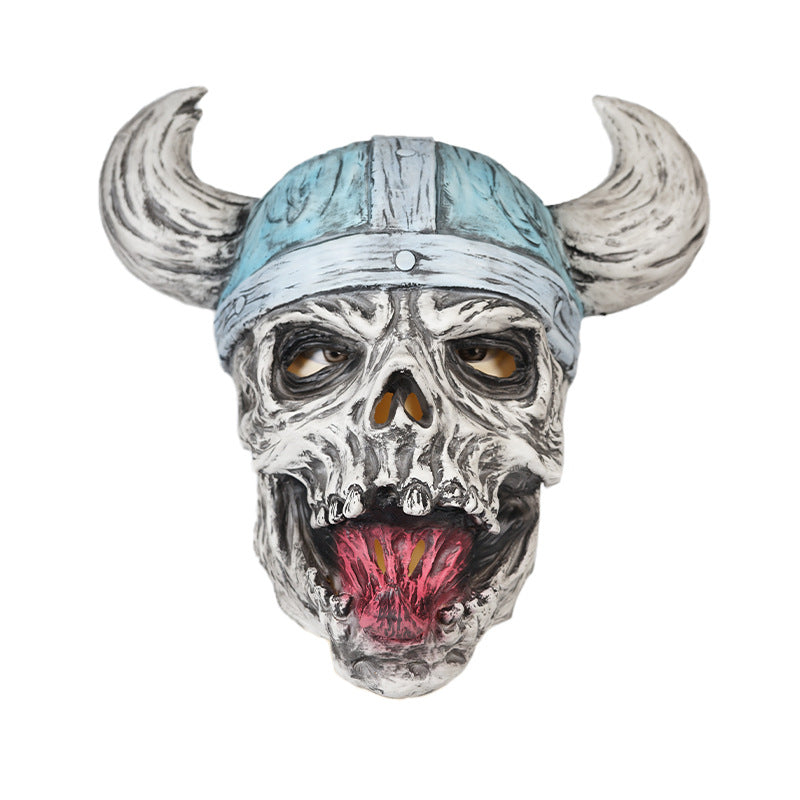 A grotesque skull mask with exaggerated features, including a long tongue and yellow teeth, is topped with a light blue Viking helmet with large, curved horns.