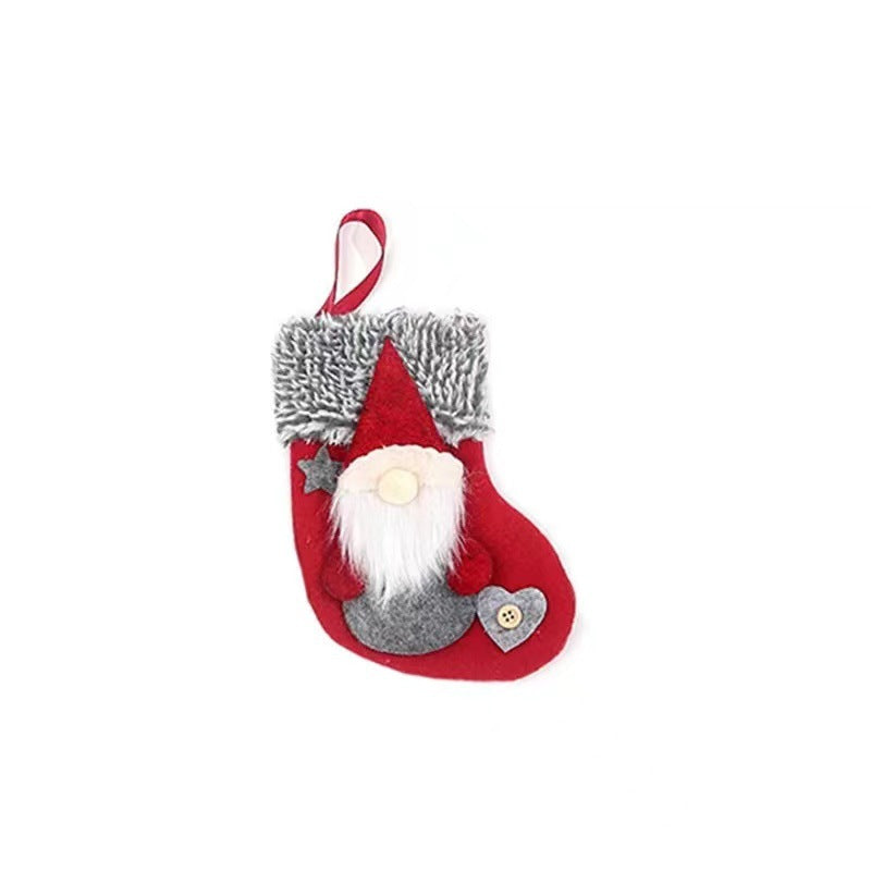 Red Christmas stocking with a gnome design, featuring a red hat, white beard, and gray outfit. It has gray fur trim and decorations like a star and heart with a button.