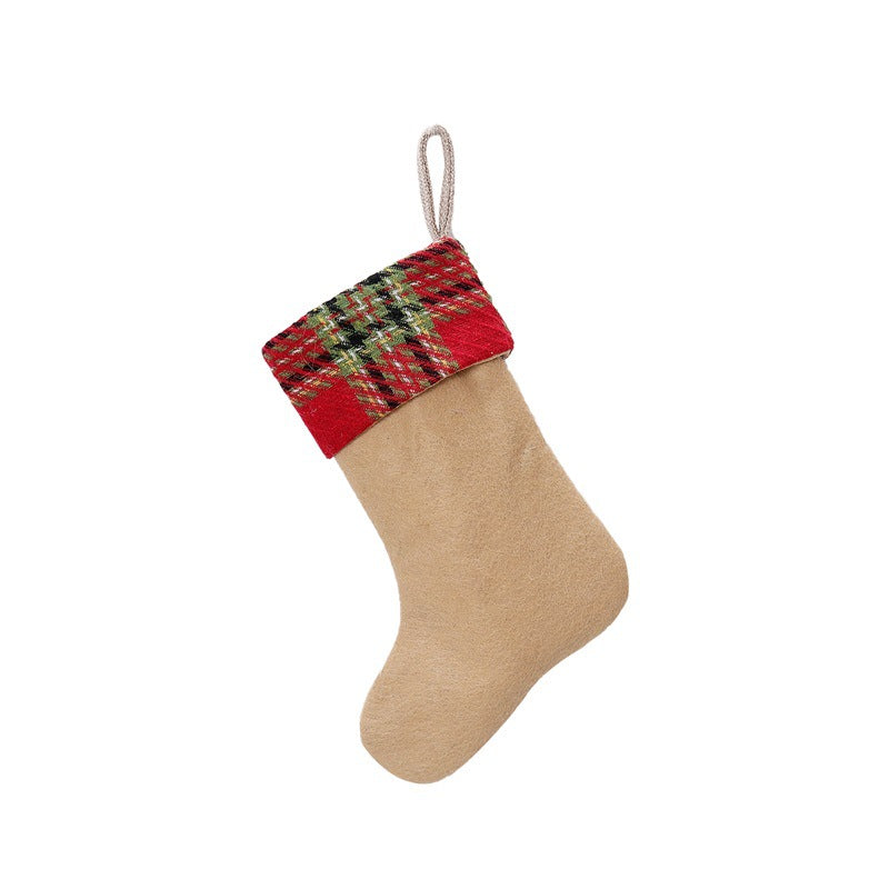 Tan Christmas stocking with a red and green plaid cuff and a small hanging loop, isolated on a white background.