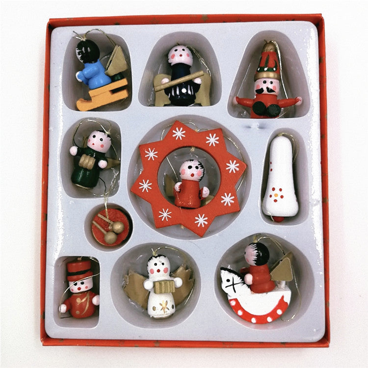 Box of nine colorful, wooden Christmas ornaments, including figures, an angel, and a rocking horse. Each piece is nestled in an individual compartment of a red and white box.