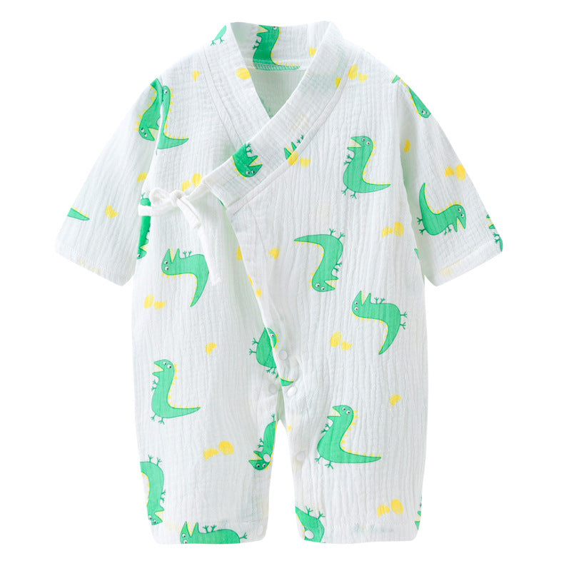 White baby romper with green dinosaur patterns and yellow accents, featuring a wrap-style design with a side tie and snap closures. Short sleeves and knee-length.