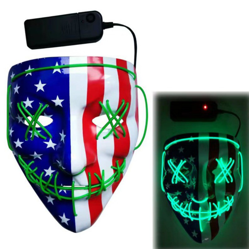 LED mask with American flag design, featuring green light-up stitches across the eyes and mouth. The mask is shown in two states: unlit and glowing in the dark.